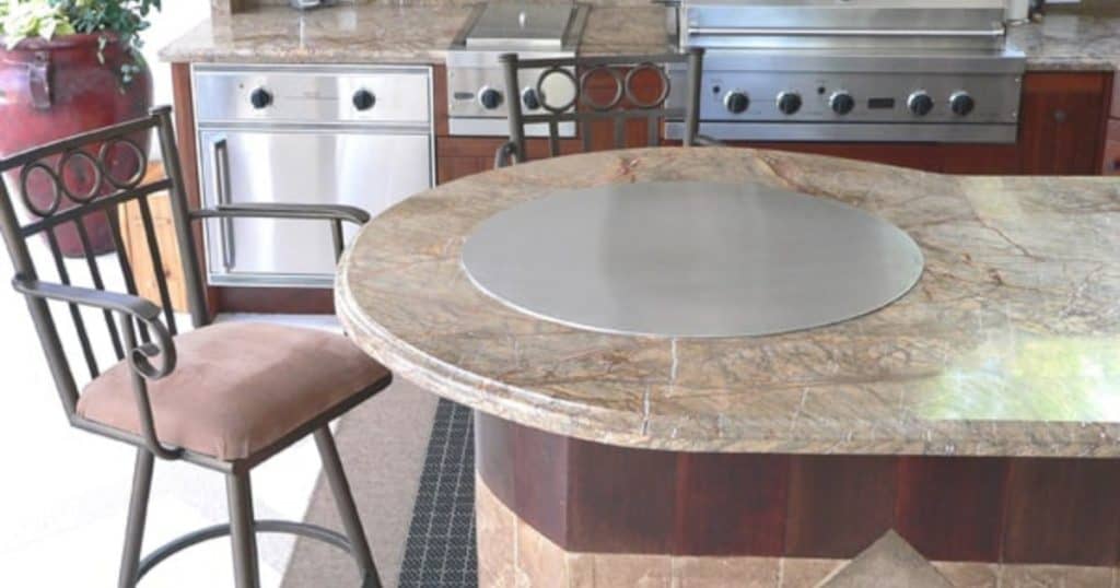 A bbq grill plate built in to a marble cooking bench. 