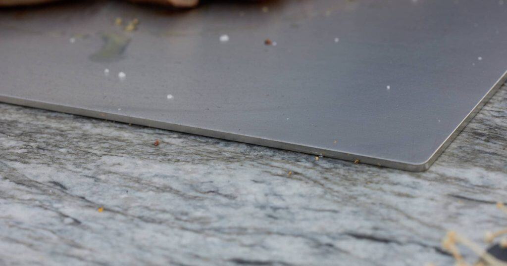 A slimline bbq grill plate on a marble bench. 
